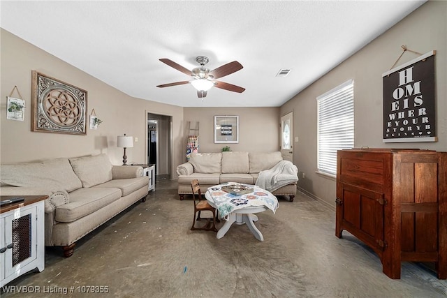 living room with a ceiling fan, visible vents, and baseboards