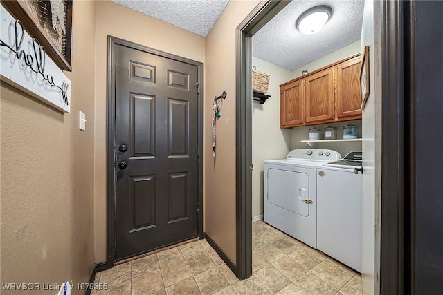 laundry area with cabinet space, a textured ceiling, baseboards, and separate washer and dryer