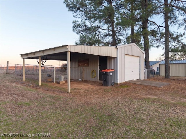 view of outdoor structure featuring driveway, fence, and an outdoor structure