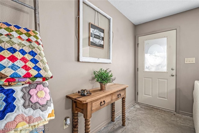 entryway featuring baseboards and concrete flooring