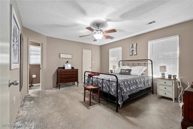 bedroom with ceiling fan, a textured ceiling, visible vents, and concrete flooring