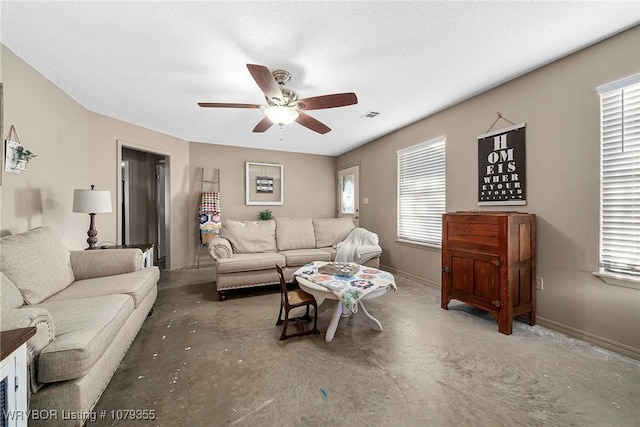 living room featuring ceiling fan, visible vents, baseboards, and a textured ceiling