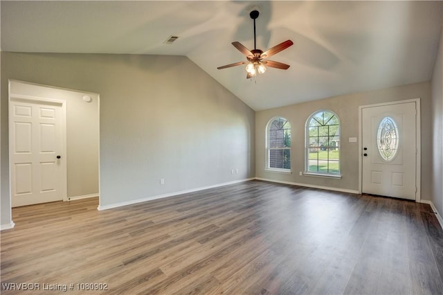 unfurnished living room with ceiling fan, wood finished floors, baseboards, and high vaulted ceiling