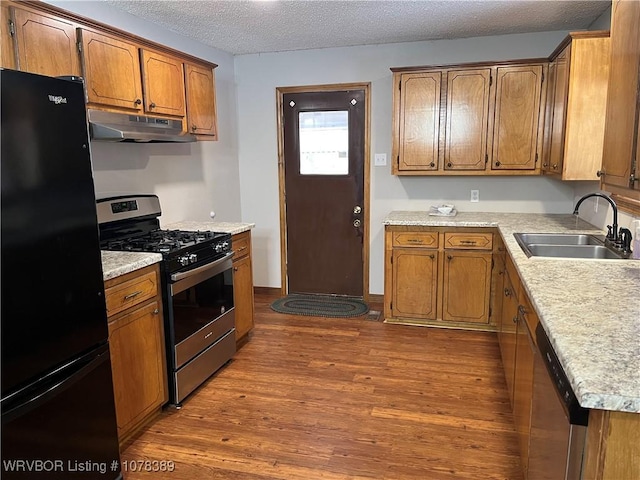 kitchen featuring sink, a textured ceiling, dark hardwood / wood-style floors, and appliances with stainless steel finishes