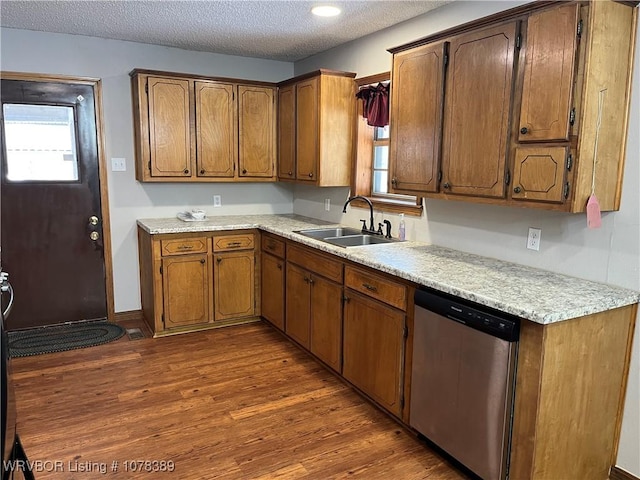 kitchen with stainless steel dishwasher, a textured ceiling, sink, and dark hardwood / wood-style floors