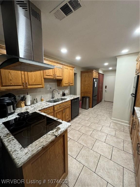 kitchen with light stone countertops, sink, tasteful backsplash, exhaust hood, and black appliances