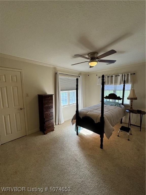 unfurnished bedroom with carpet flooring, a textured ceiling, ceiling fan, and crown molding