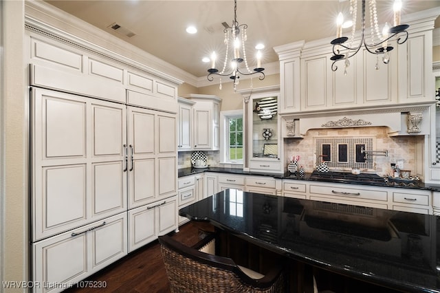 kitchen featuring crown molding, a chandelier, decorative light fixtures, decorative backsplash, and a breakfast bar