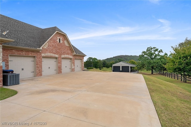 view of home's exterior featuring a yard, a garage, and central air condition unit