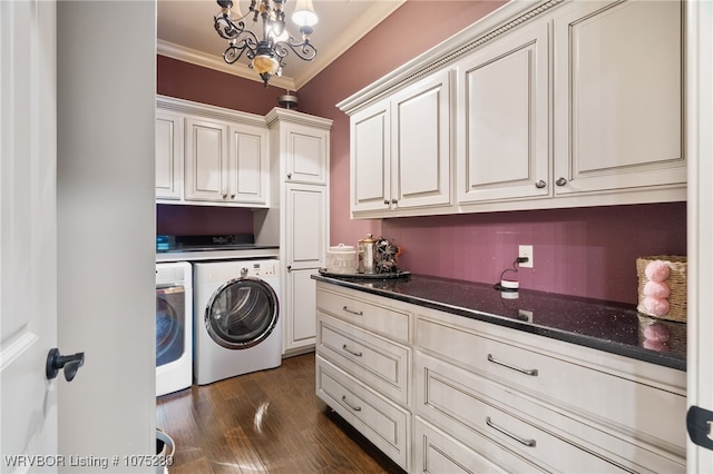 clothes washing area featuring cabinets, dark hardwood / wood-style flooring, crown molding, a notable chandelier, and washing machine and clothes dryer