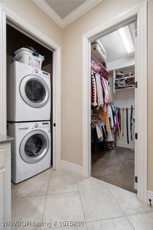 laundry room featuring crown molding, light carpet, and stacked washer / drying machine