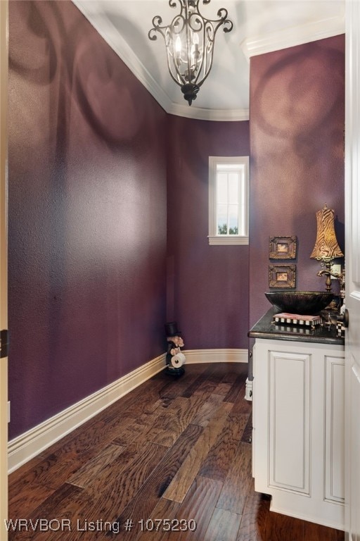 interior space with a notable chandelier, dark hardwood / wood-style floors, sink, and crown molding