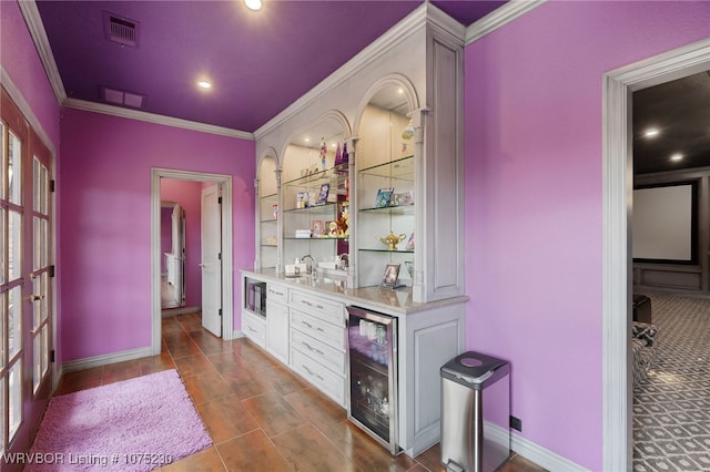 bar featuring white cabinetry, built in microwave, sink, wine cooler, and crown molding