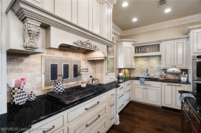 kitchen with dark wood-type flooring, black gas cooktop, backsplash, white cabinets, and ornamental molding