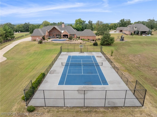 exterior space with tennis court and a yard