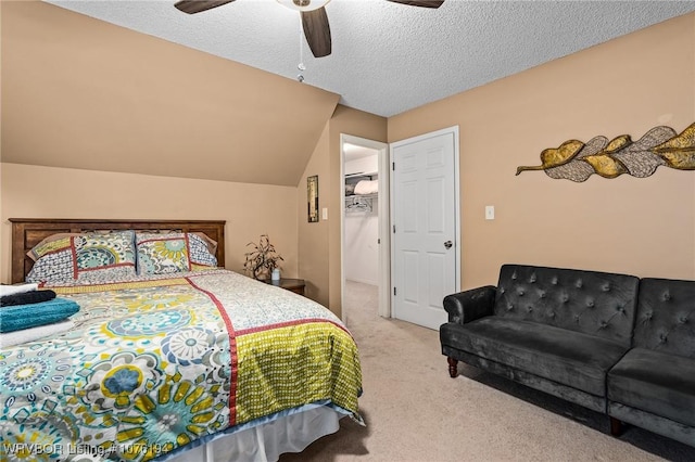 bedroom with a textured ceiling, light colored carpet, vaulted ceiling, and ceiling fan