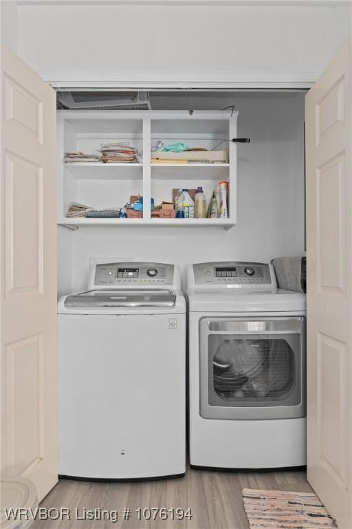 clothes washing area featuring washer and clothes dryer and hardwood / wood-style floors