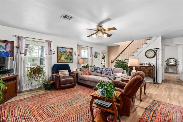 living room featuring a wealth of natural light, ceiling fan, and light wood-type flooring