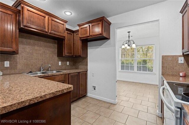 24401 Brazil Creek Loop, Shady Point, OK 74956 - kitchen with a sink, light tile patterned flooring, baseboards, decorative backsplash, and hanging light fixtures