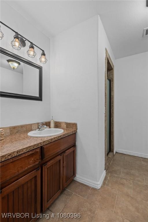 24401 Brazil Creek Loop, Shady Point, OK 74956 - bathroom featuring baseboards, a shower with door, vanity, and visible vents
