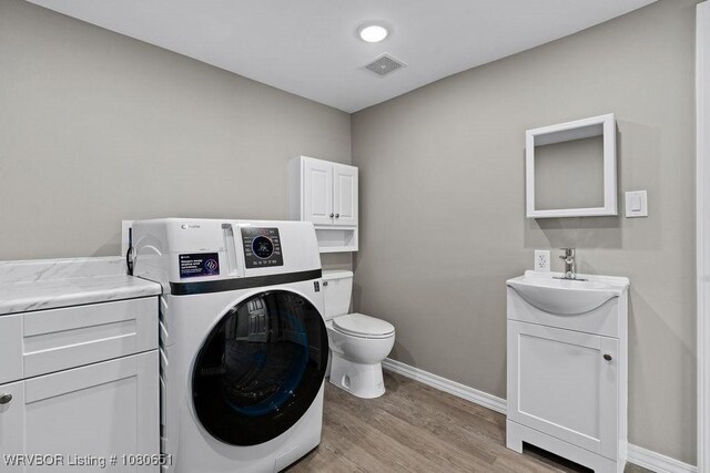 11 N 13th St, Van Buren, AR 72956 - interior space with toilet, baseboards, washer / dryer, wood finished floors, and visible vents