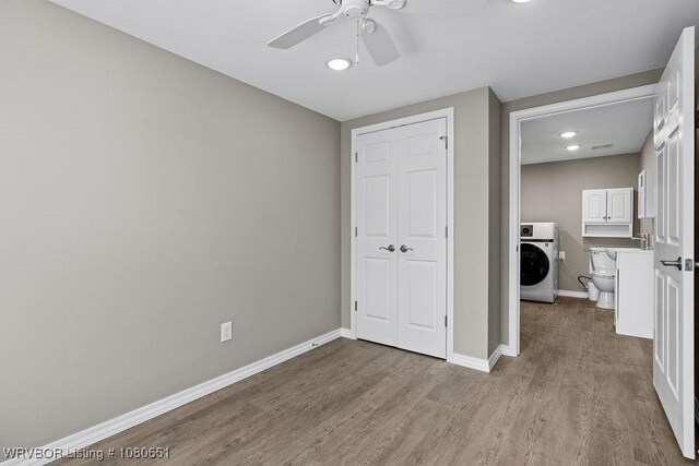 11 N 13th St, Van Buren, AR 72956 - unfurnished bedroom with a closet, wood finished floors, baseboards, washer / clothes dryer, and recessed lighting