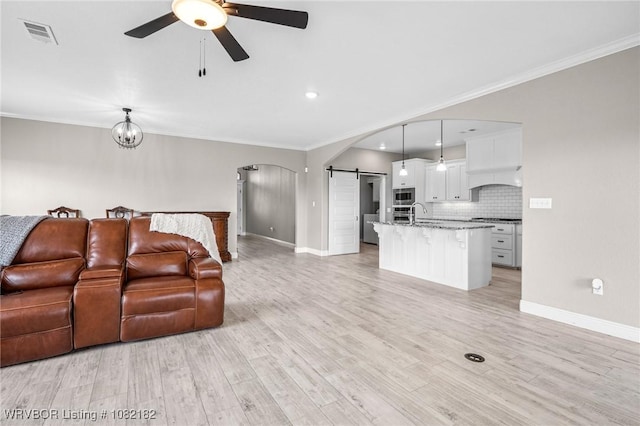9505 Harmony Ridge Rd, Fort Smith, AR 72916 - living area featuring arched walkways, a barn door, ceiling fan, ornamental molding, and recessed lighting