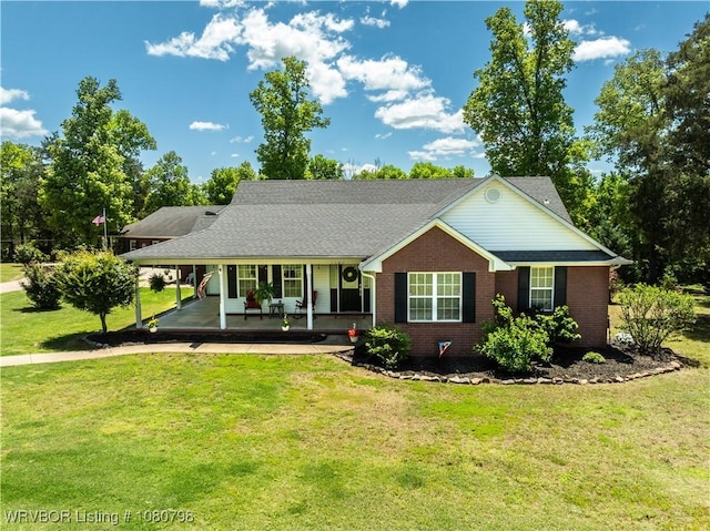 view of front of property with a front yard, an attached carport, brick siding, and covered porch