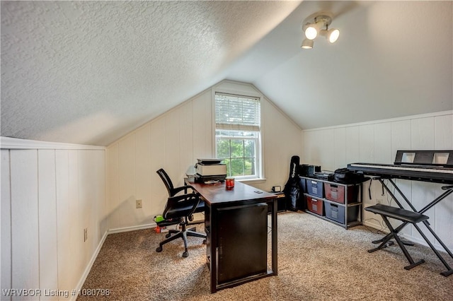 office with a textured ceiling, a decorative wall, carpet, and vaulted ceiling