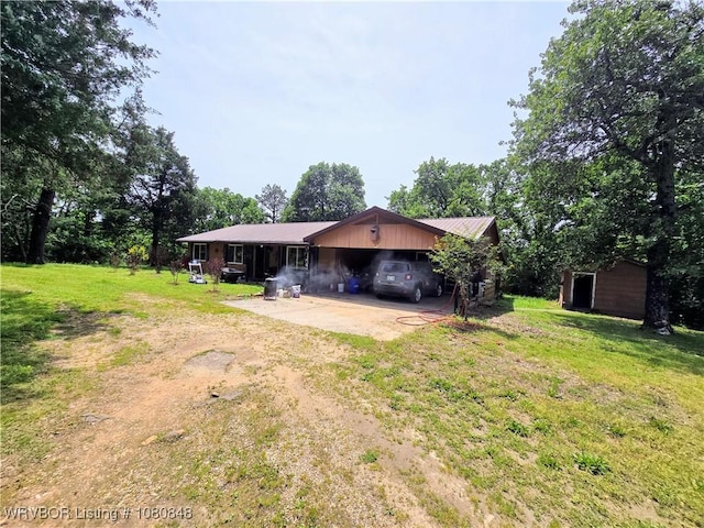 back of house featuring a yard, driveway, and a carport