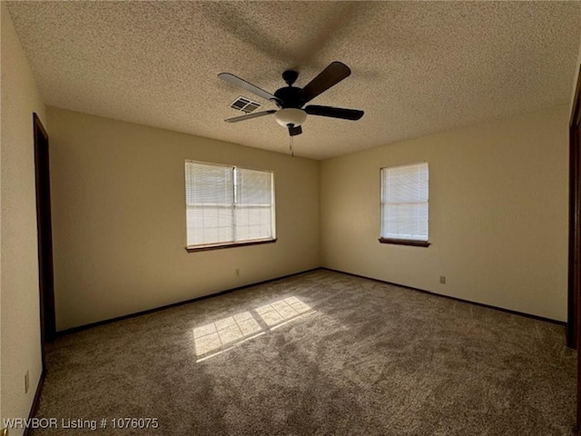 unfurnished room featuring carpet, ceiling fan, and a textured ceiling