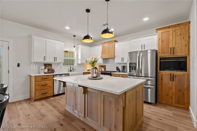 1905 Barnes St, Pocola, OK 74902 - kitchen with visible vents, stainless steel appliances, decorative backsplash, and light wood finished floors