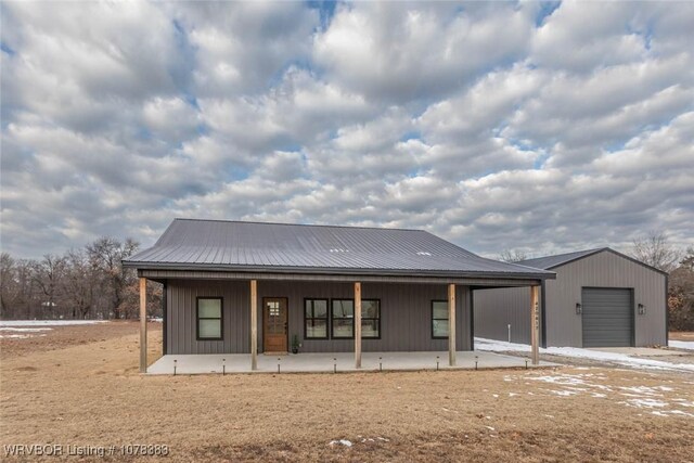 view of front of property with a garage, a porch, and an outdoor structure