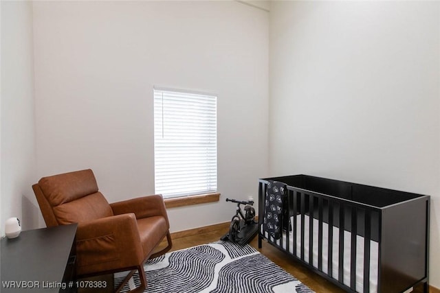 bedroom featuring dark hardwood / wood-style floors and a crib