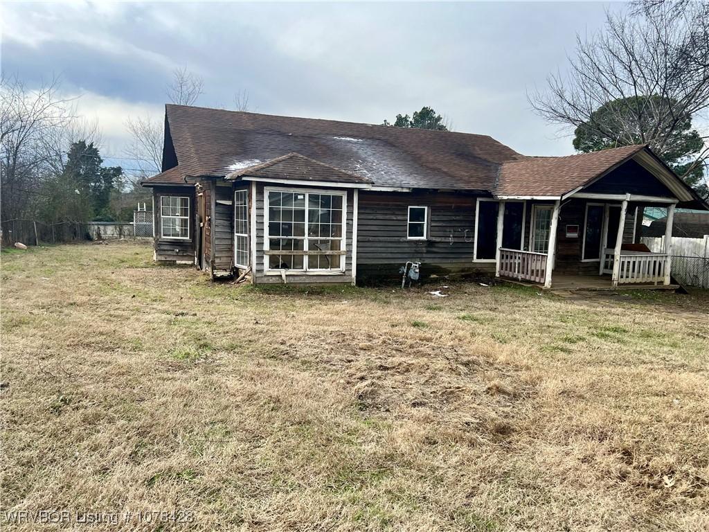 back of property with a porch and a lawn