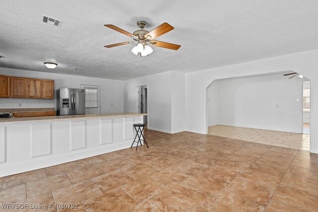 4308 25th St, Fort Smith, AR 72901 - unfurnished living room with a textured ceiling, arched walkways, a ceiling fan, and visible vents