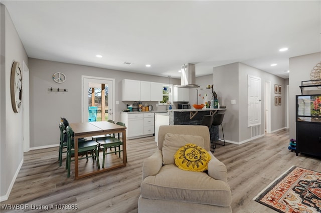 interior space featuring light wood-type flooring, baseboards, and recessed lighting