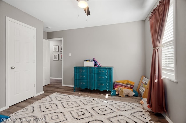 bedroom with wood finished floors, a ceiling fan, and baseboards