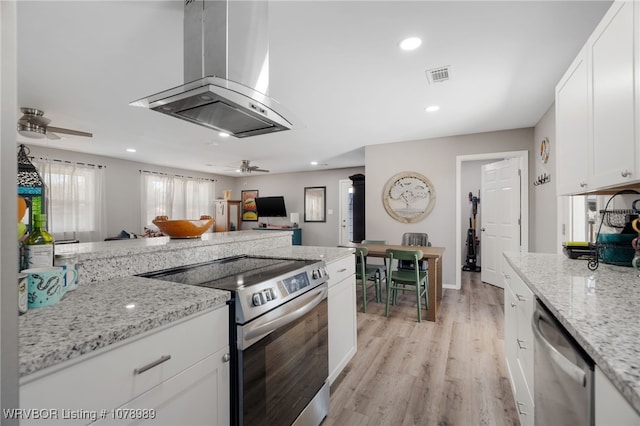 kitchen featuring extractor fan, visible vents, light wood-style floors, white cabinets, and appliances with stainless steel finishes