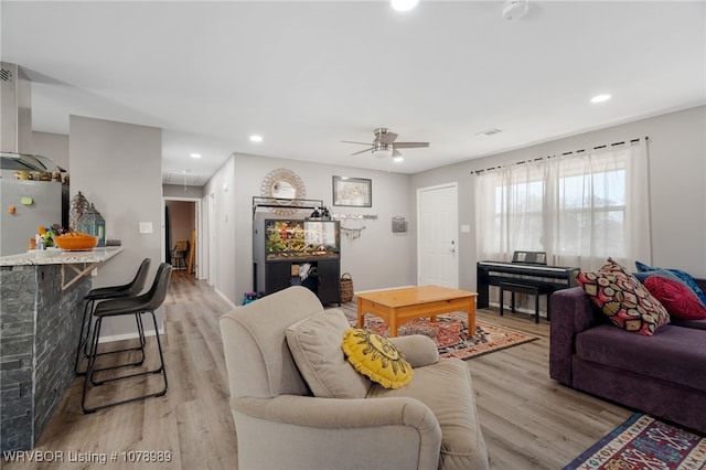 living area featuring light wood finished floors, attic access, and recessed lighting