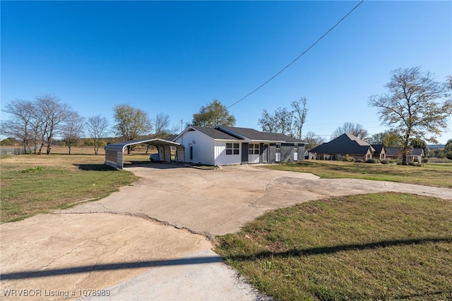 view of front of house featuring concrete driveway, a carport, and a front yard