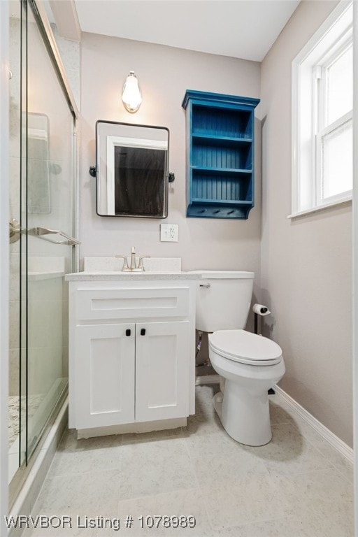 full bath featuring toilet, a shower stall, baseboards, and vanity