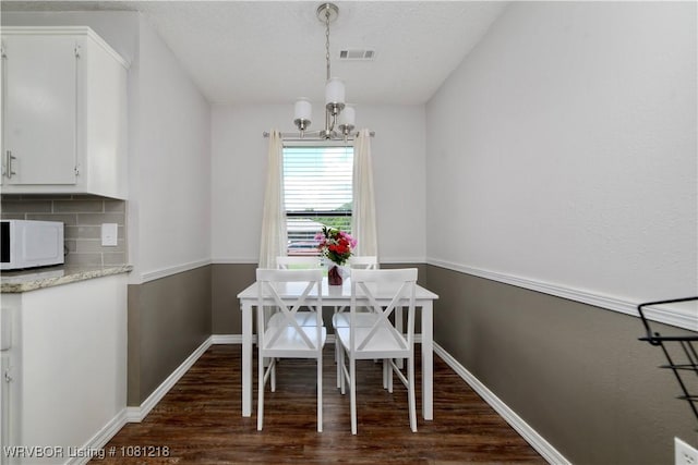 128 Saskatchewan Rd, Roland, OK 74954 - dining room featuring a chandelier, dark wood-type flooring, and baseboards