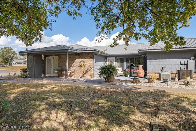 rear view of house with a patio area, a yard, and central AC