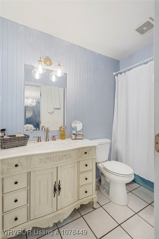 bathroom featuring toilet, tile patterned floors, wood walls, and vanity