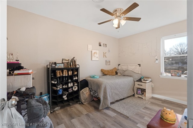 bedroom with light hardwood / wood-style floors and ceiling fan