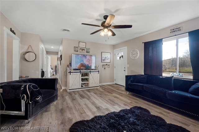 living room with ceiling fan and light hardwood / wood-style flooring