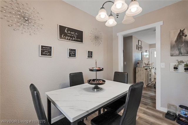 dining area featuring hardwood / wood-style floors and a notable chandelier