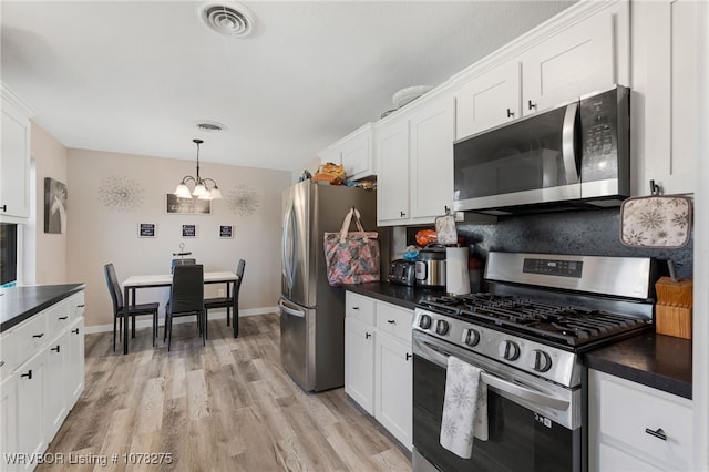 kitchen featuring white cabinets, decorative light fixtures, stainless steel appliances, and a notable chandelier