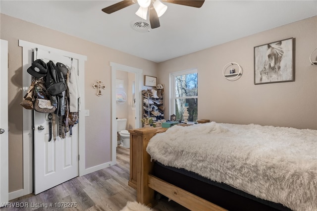 bedroom featuring hardwood / wood-style floors, ceiling fan, and ensuite bathroom